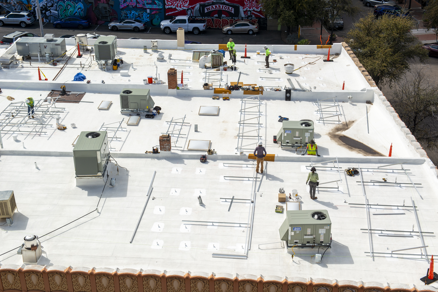 Construction workers on a roof complete a capital improvement project.