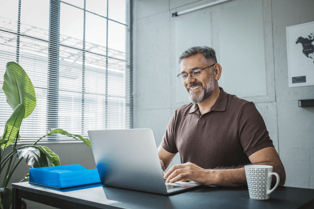 man sitting at desk with laptop